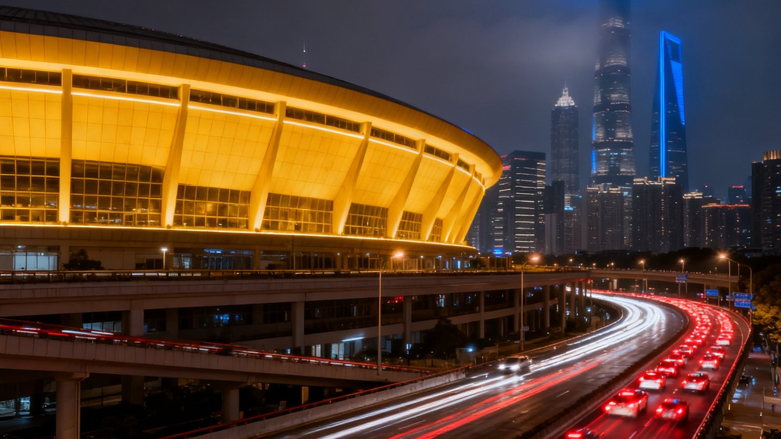 上海体育场夜景，流线型建筑外立面被暖色灯光照亮，周边高架道路车流如织，远处陆家嘴摩天楼群若隐若现